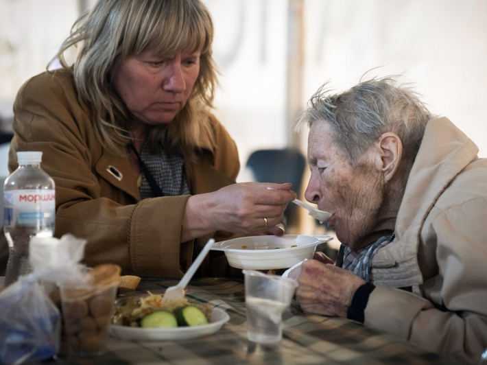 Люди, які прибули з Маріуполя, їдять у центрі для внутрішньо переміщених осіб у Запоріжжі, 3 травня 2022 року, фото: AP photo / Євгеній Малолєтка