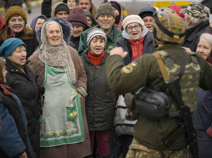 Цивільні радіють разом з українським військовослужбовцем, тоді як колона військової та гуманітарної техніки прибуває до звільненої від російських окупантів Бучі, 2 квітня 2022 року, фото: AP Photo / Vadim Ghirda
