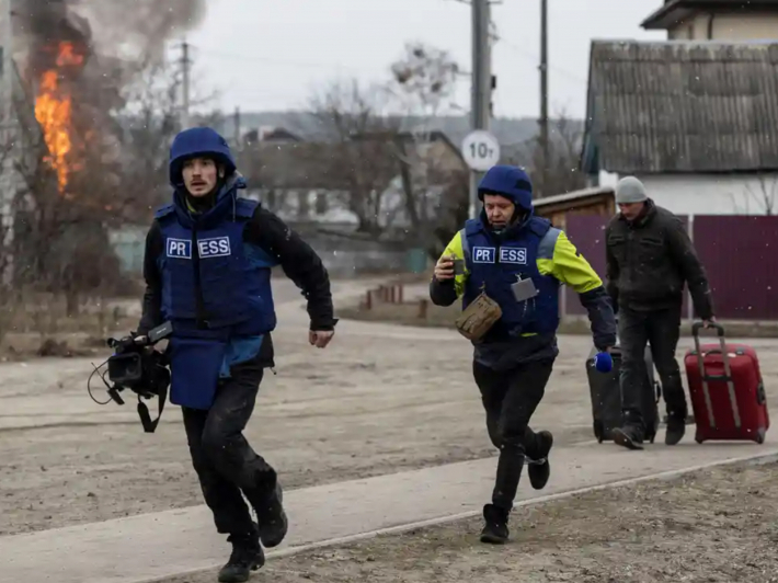 Журналісти біжать в укриття під час обстрілів в Ірпені під Києвом, березень 2022 року, фото: Reuters/Карлос Барріа