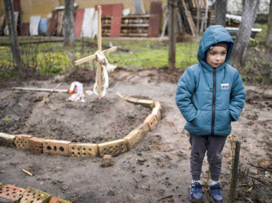 6-річний Влад Танюк стоїть біля могили своєї матері у дворі їхнього будинку на околиці Києва, 4 квітня 2022 року, фото: AP Photo/Rodrigo Abd