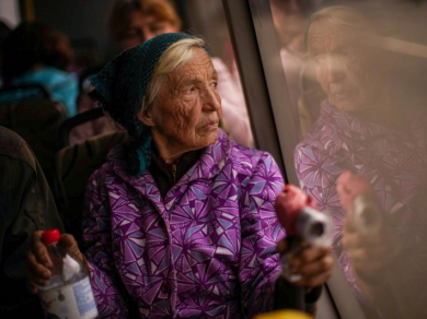 85-річна Катерина Ходжа їде автобусом з центру прийому переміщених осіб у Запоріжжі, 29 квітня 2022 року, фото: AP Photo / Francisco Seco