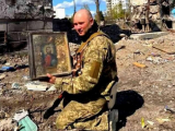 Військовослужбовець триває вцілілу ікону Ісуса Христа, яку дістали з-під завалів зруйнованої Бородянки