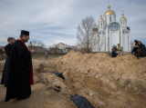 Блаженніший Святослав молиться над братською могилою у Бучі, 7 квітня 2022 року