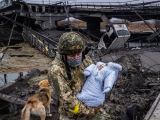 Український військовослужбовець рятує дитину під час російських бомбардувань, фото: Timothy Fadek/Redux for CNN